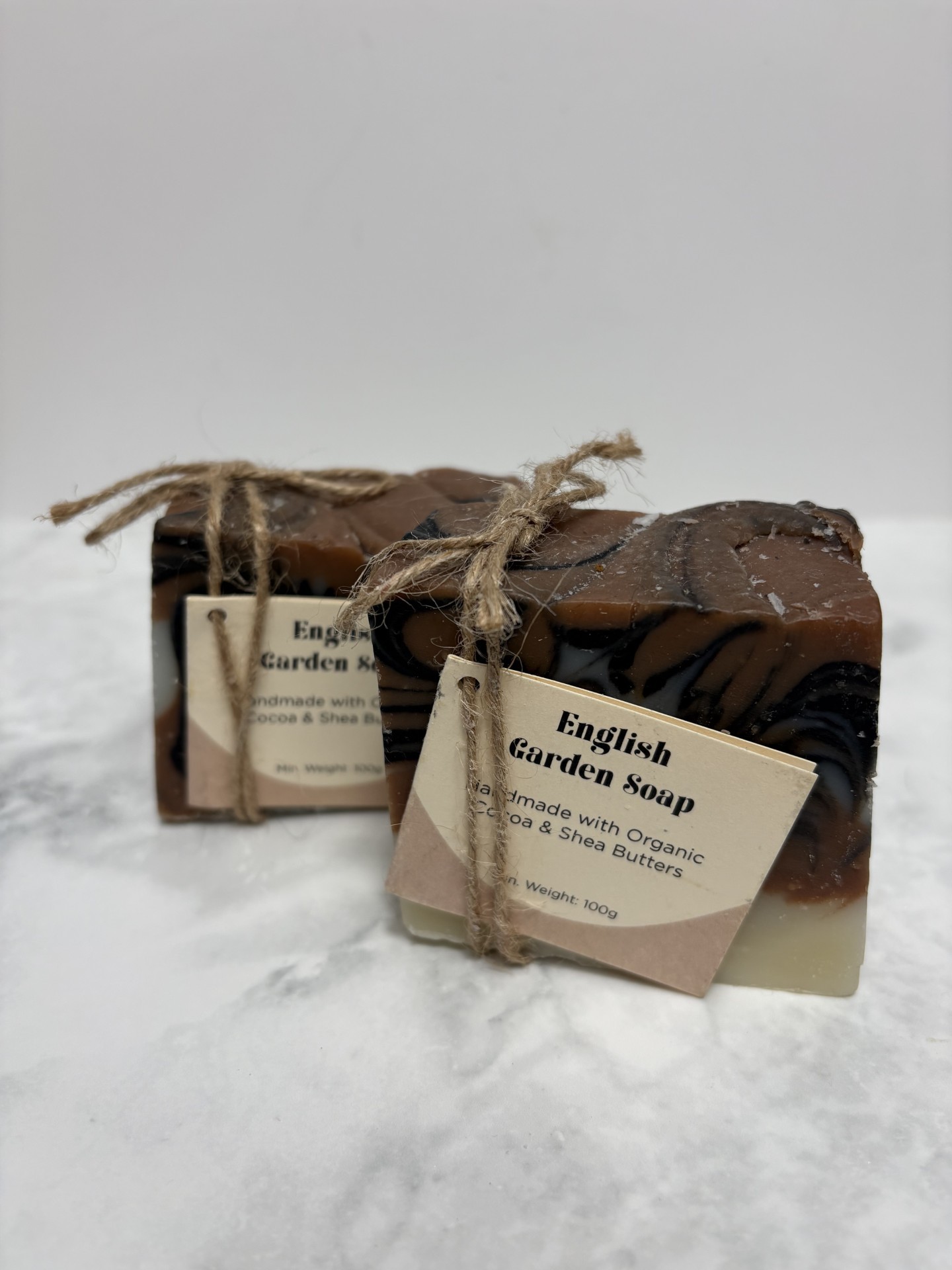Two bars of pink, white and black soap in a swirl pattern