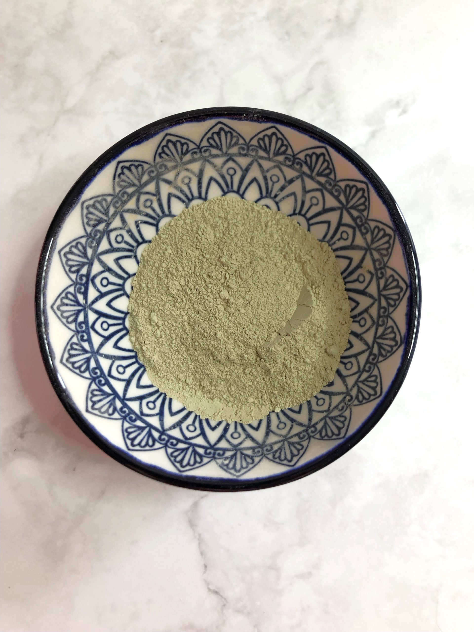 Green clay and cucumber facemask in bowl