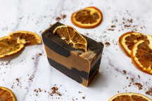Brown and orange soap bar with a slice of dried orange peel on top.