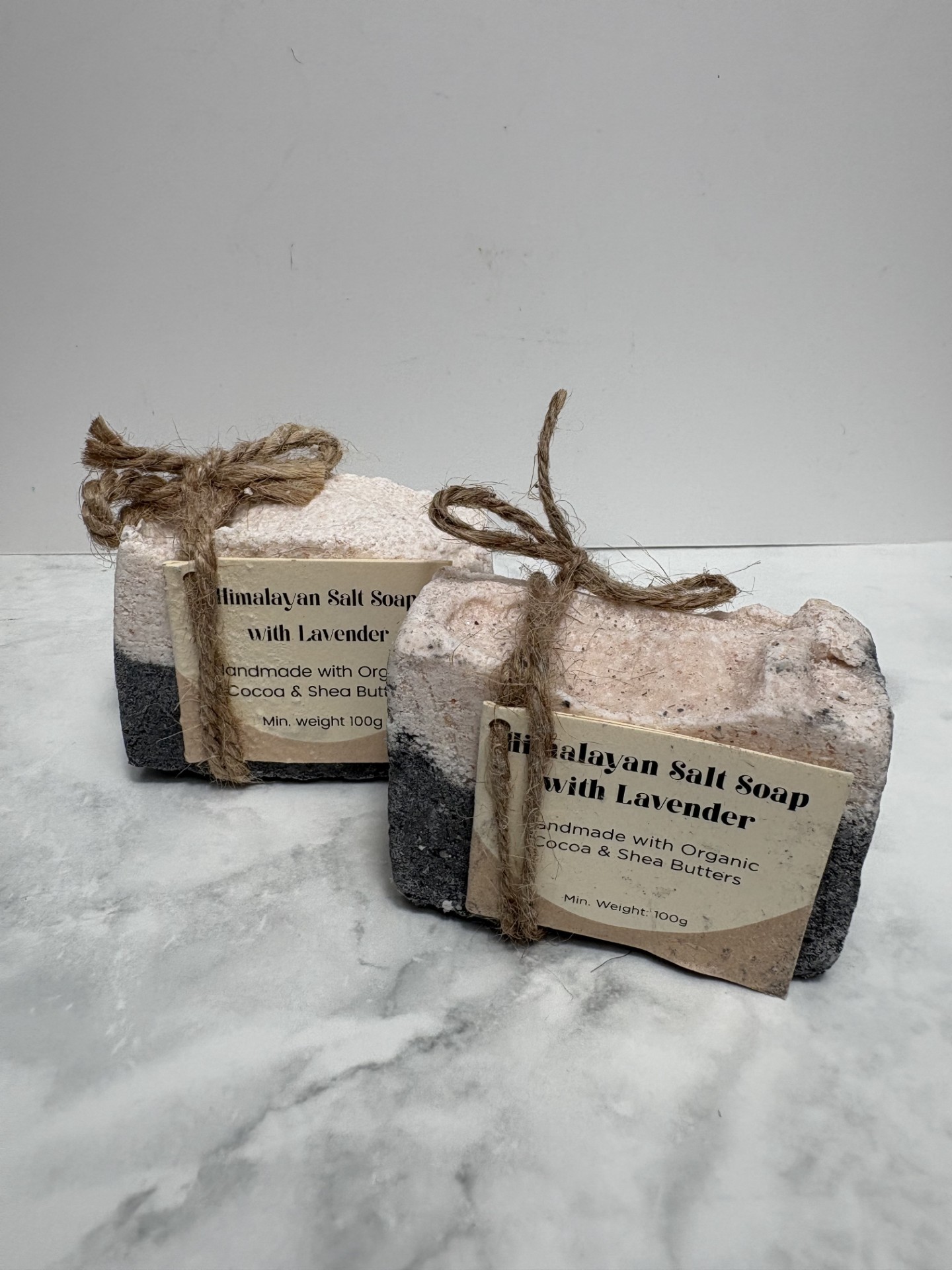 Two bars of black and pink coloured salt soap.