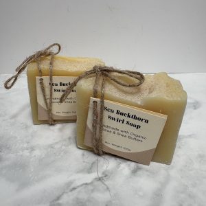 Two bars of pale yellow soap with a card label attached to the front of each