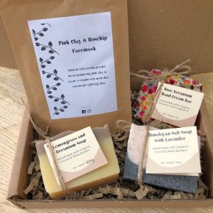 Gift box containing himalayan lavender salt soap, lemongrass and geranium soap, rose geranium hand cream bar wrapped in floral beeswax wrap and a sachet of facemask powder.