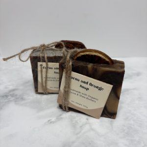 Two bars of brown and orange swirled soap with a slice of dried orange peel in the top of each.