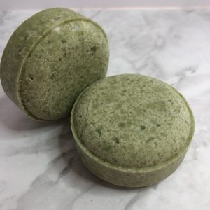 Two green circular shampoo bars